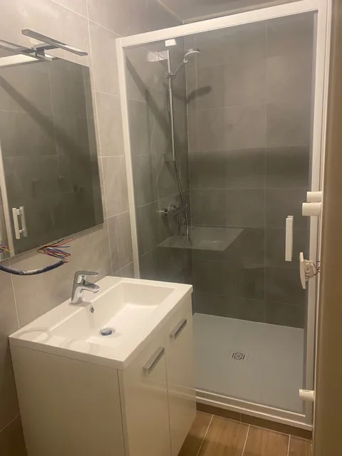 La salle d'eau terminée, avec douche vitrée et meuble vasque