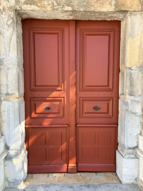La même porte poncée et repeinte en rouge